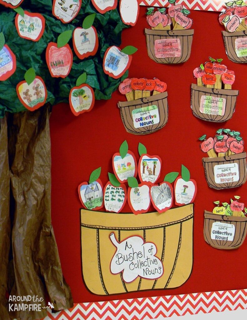 Fall bulletin boards include apple themes like this one. A tree has apples in it and a basket and several bushels of apples are seen. Text reads "a bushel of collective nouns." 