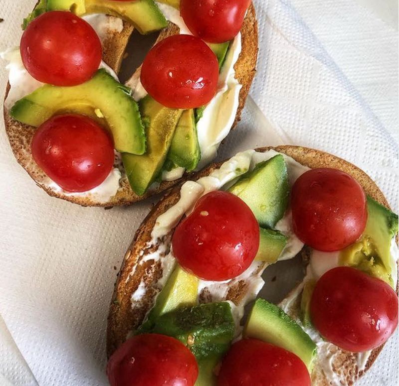 Teacher lunch of toasted bagel topped with cream cheese, avocado, and tomato