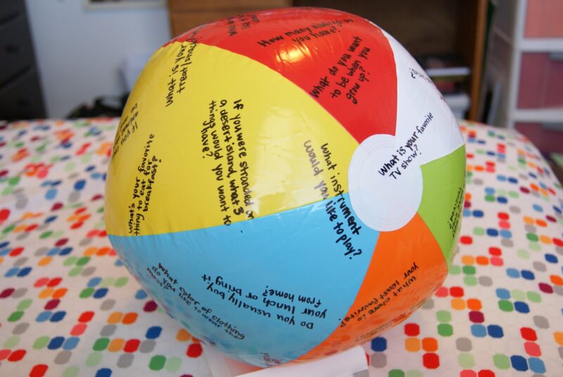 beach ball with writing on each side for students to practice answering questions during a classroom game