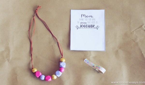 A necklace is made from suede cord and pink, purple, and yellow beads (Mother's Day crafts for kids)