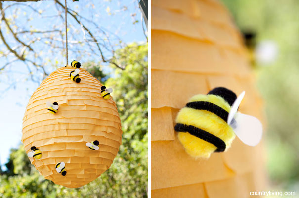A paper mache beehive with pom pom bees on it as an example of summer crafts for kids