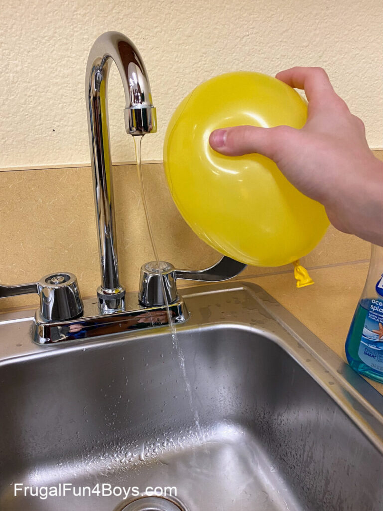 balloon held up to a stream of water for an electricity experiment