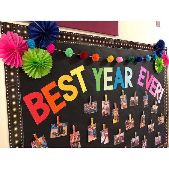 A bulletin board says Best Year Ever in brightly colored letters. It has photos from the year attached to it.