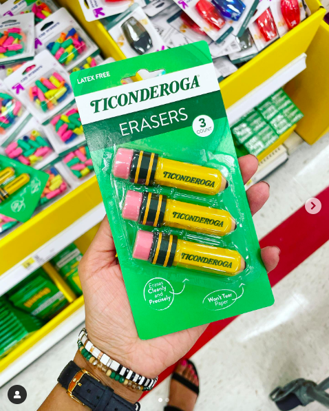 A teacher's hand holding a three pack of Ticonderoga erasers as an example of dollar store hacks for the classroom 