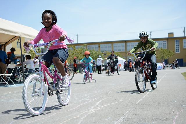 child biking in a school parking lot 