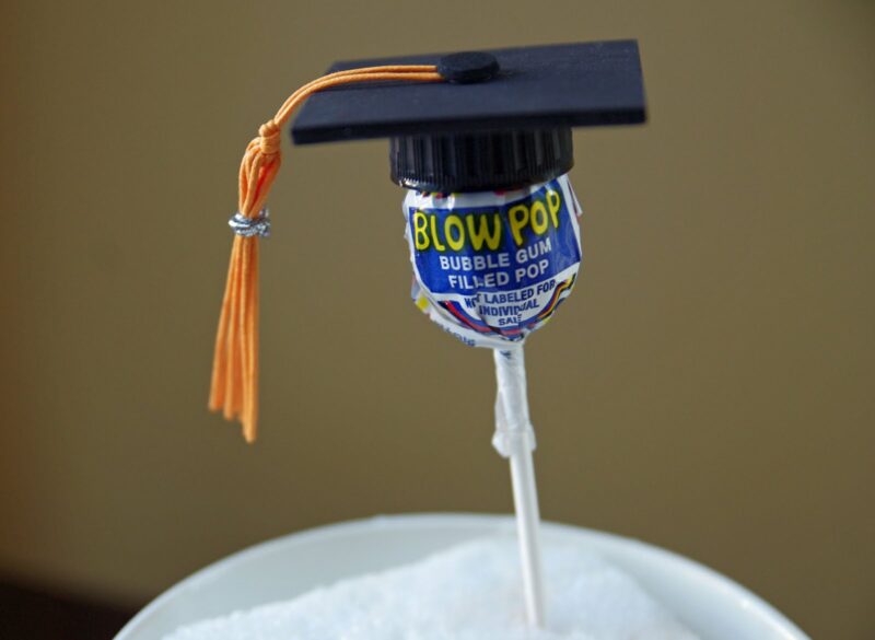 Preschool graduation ideas can include treats like these blowpops with little graduation caps on them.