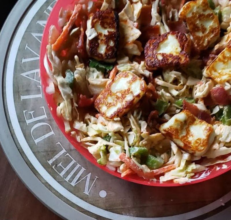 Salad with lettuce, cabbage, tomato, bacon, and bread cheese topping