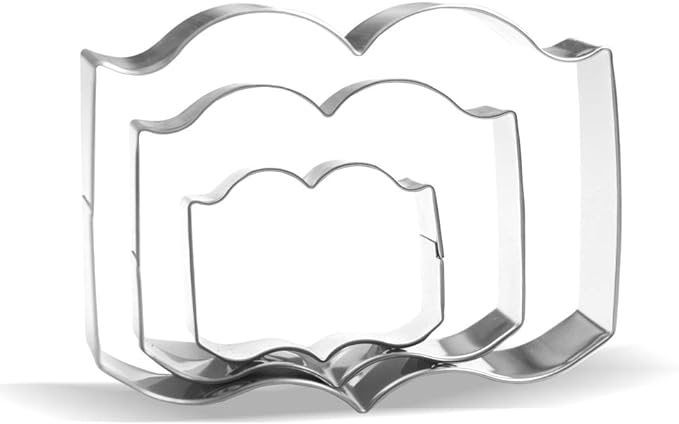 three cookie cutters in the shape of an open book 