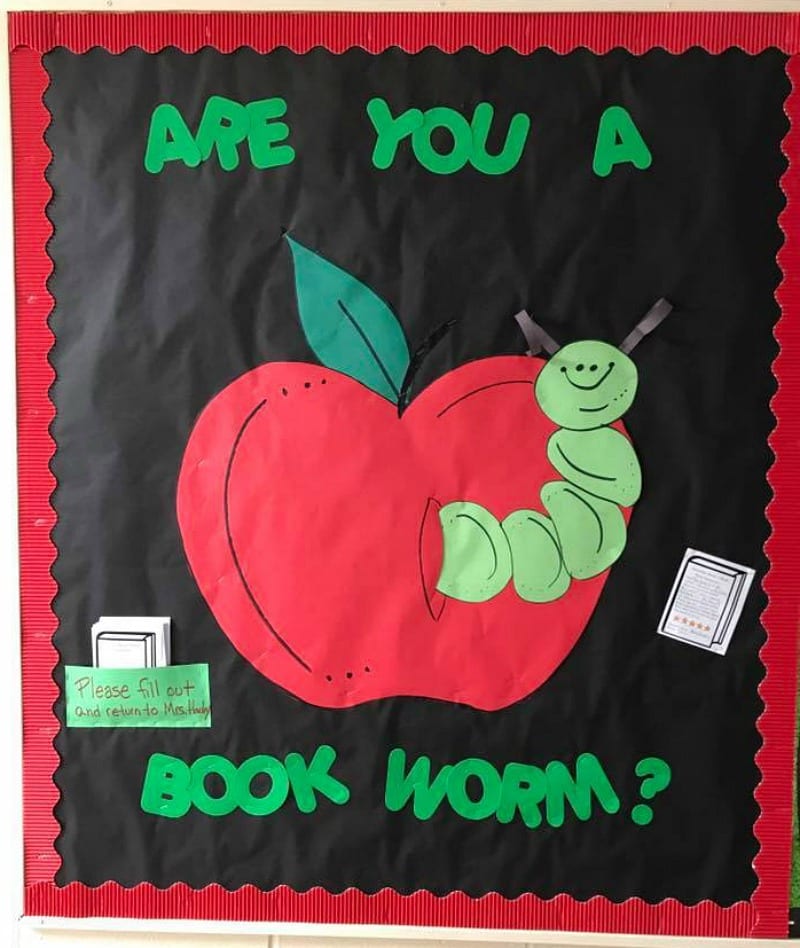 Bulletin board with a large apple with a worm coming out of it. Text reads Are you a bookworm?