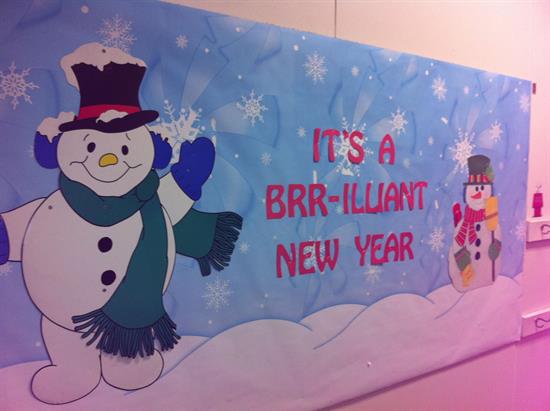 A bulletin board has two snowmen on it and says It's a brrrr-illiant new year.