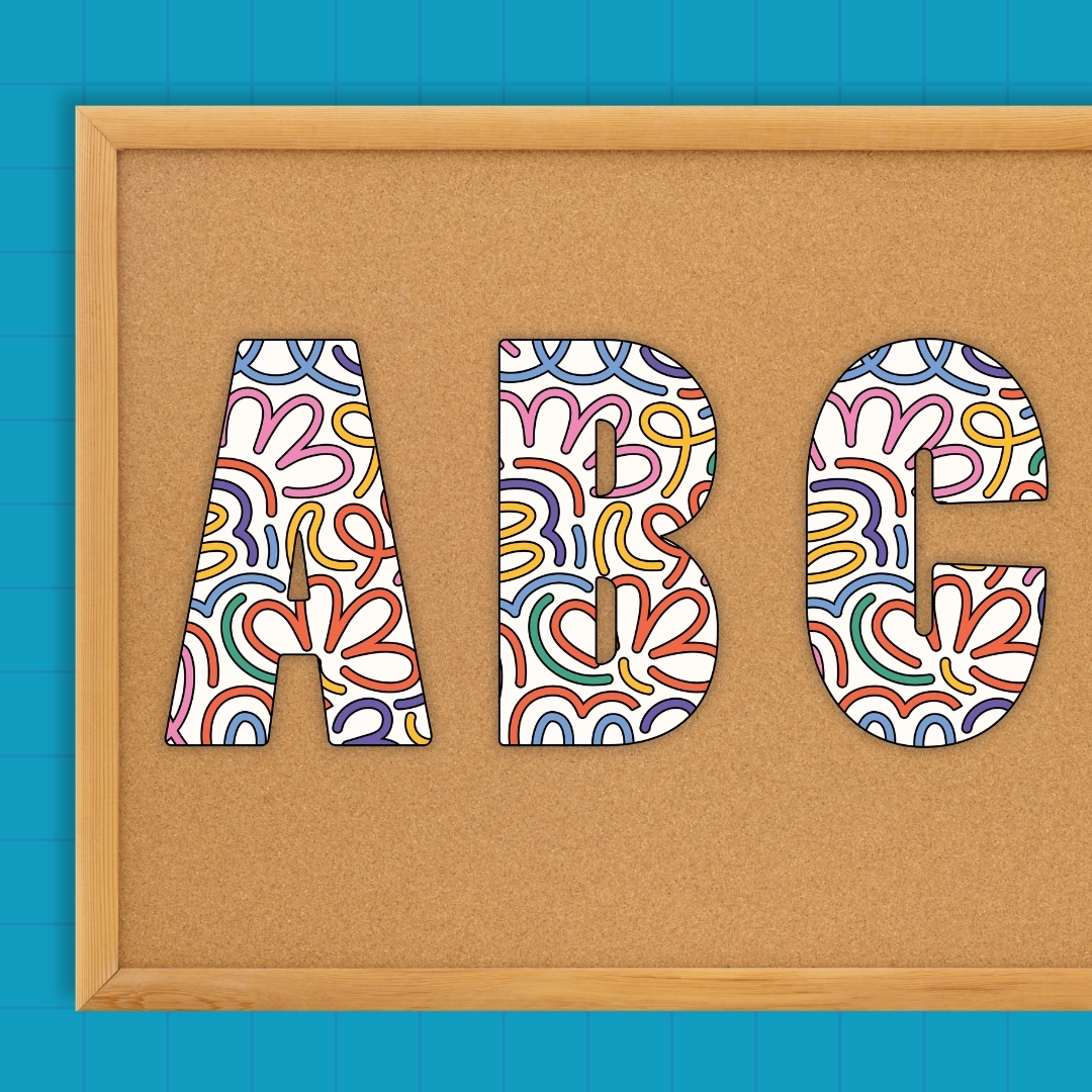 Colorful squiggle-patterned letters A, B, and C displayed on a cork board