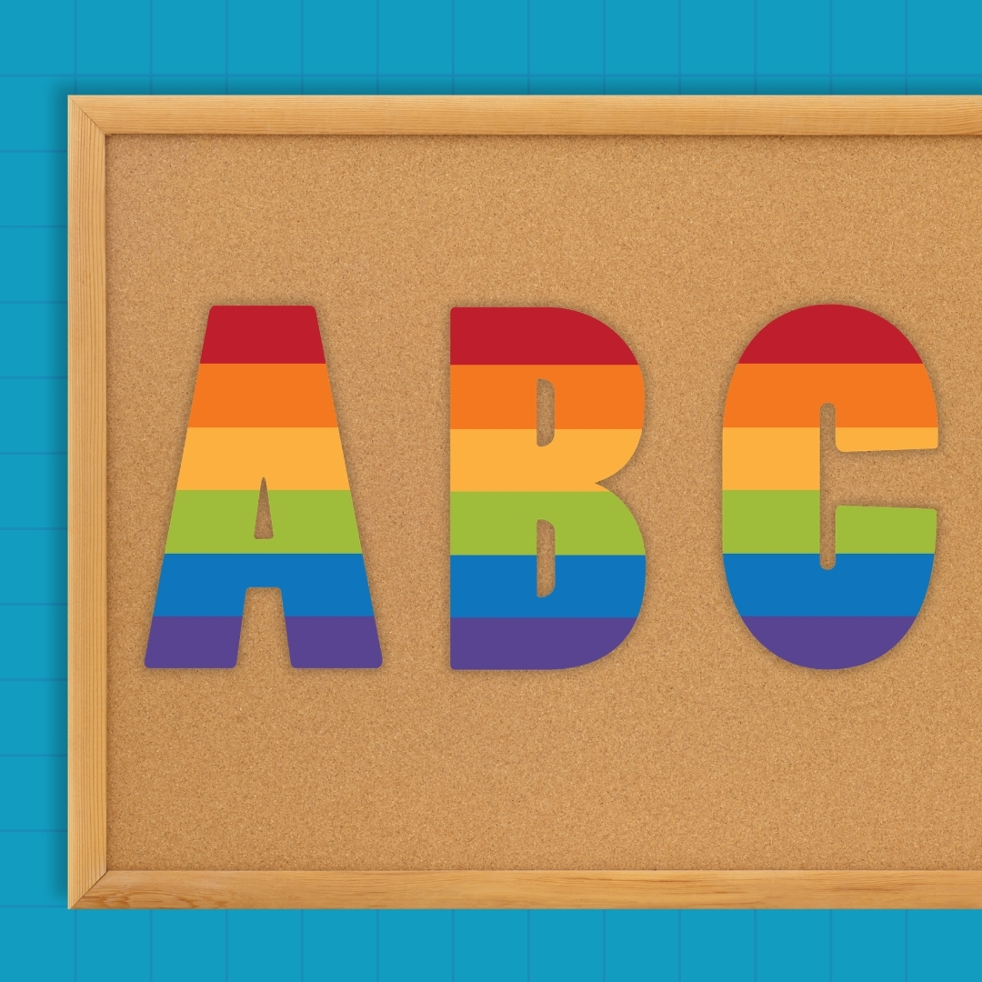 Rainbow striped bulletin board letters spelling ABC on a cork board
