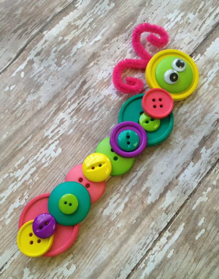 Colorful buttons are glued together to create an adorable little caterpillar as an example of summer crafts for kids