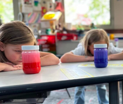Two students stare at a calm down jar on their desks