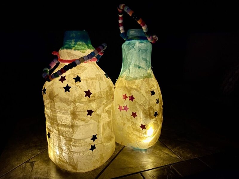 Summer camp activities include lanterns like these homemade ones that are lit up. They are decorated with stars. 