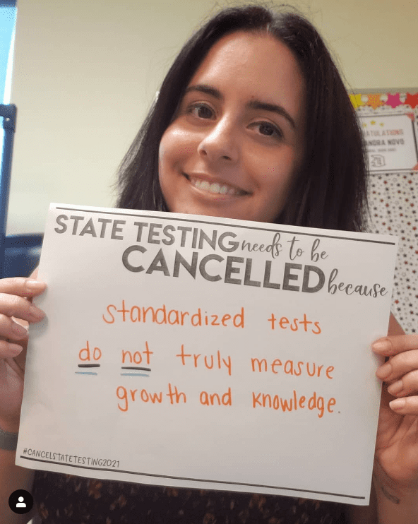 Teacher holding sign in support of canceling state tests