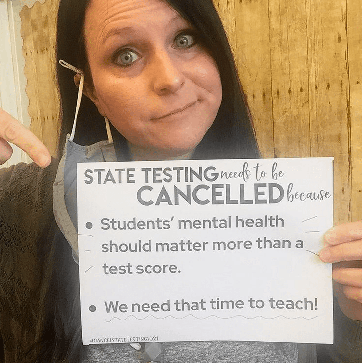Teacher holding sign to support cancel state testing movement