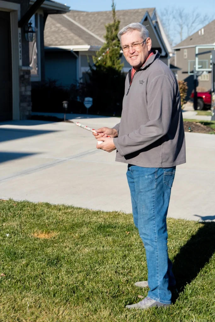 man holding a marshmallow and candy cane for a candy cane game 