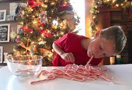 kid picking up candy canes with his mouth for a candy cane game 
