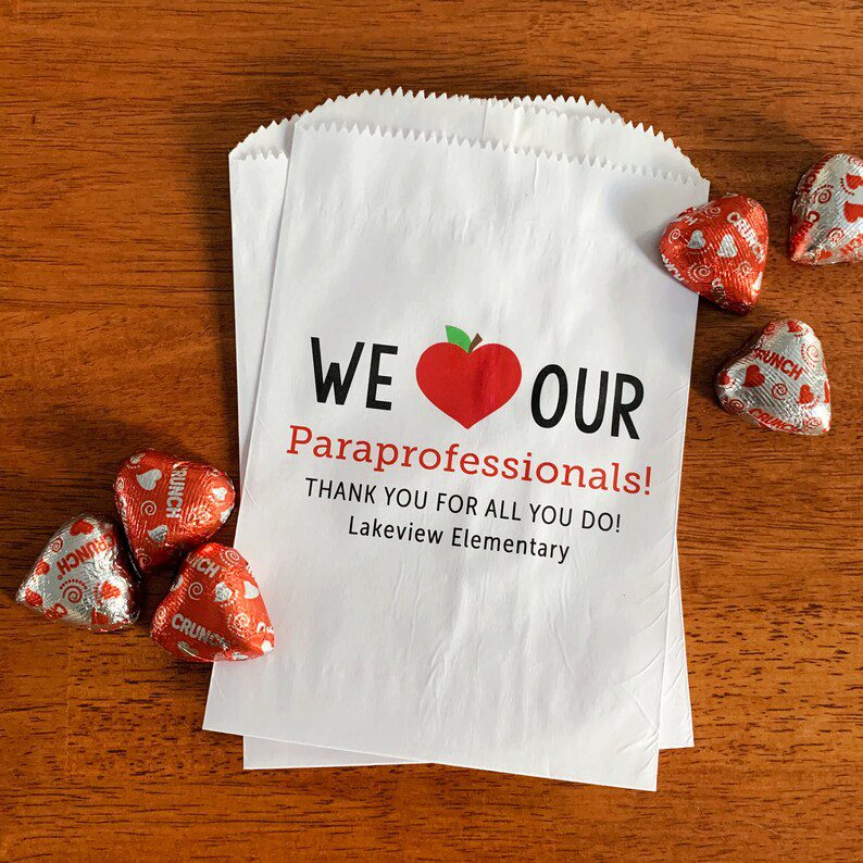 A white paper bag says We heart Our Paraprofessionals as an example of gifts for paraprofessionals