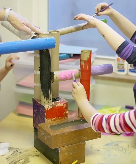 Children work together to build a castle from recycled cardboard materials