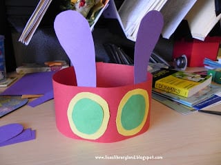 Children's headband made from construction paper- red for the band, purple for the antennae and green and yellow for the eyes