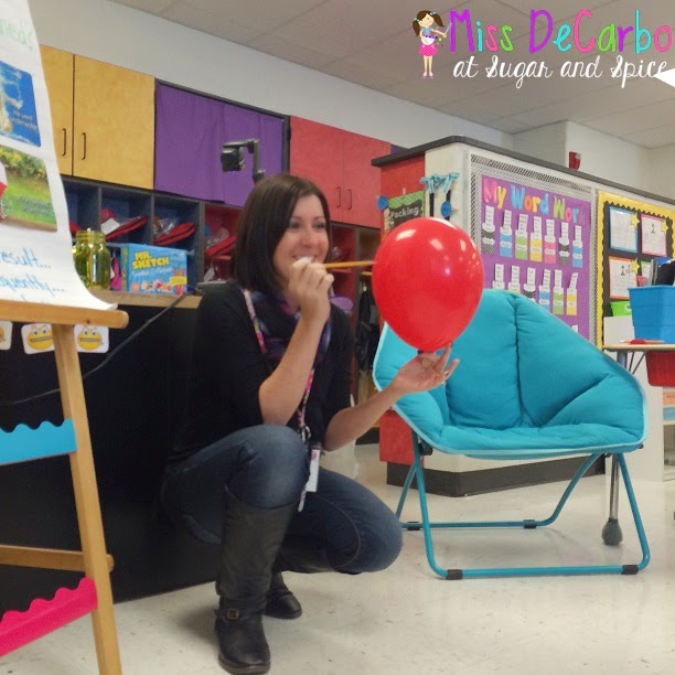 teacher squatting down holding a pin to a balloon for a cause and effect activity