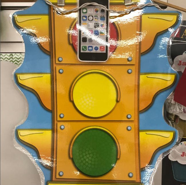 A large illustration of a stoplight with a cellphone image placed on the red light (Cell Phones in Class)