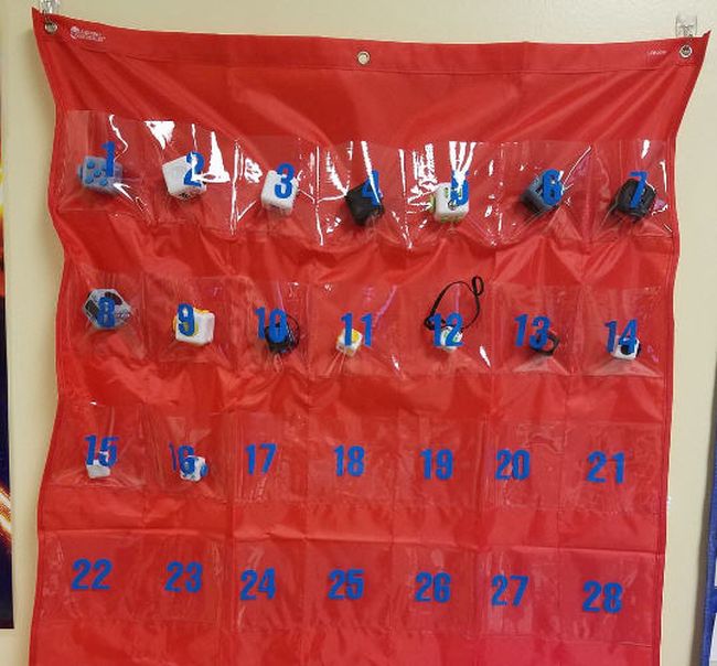 Numbered pocket chart with fidget cubes in the pockets (Cell Phones in Class)