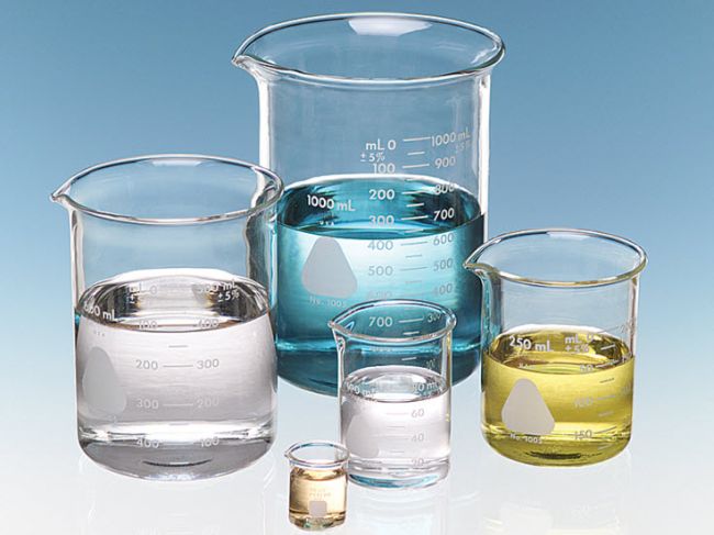 Five glass beakers filled with various colored liquids