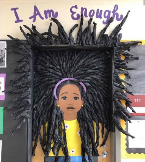 Classroom door decorated with an illustration of a young Black woman, with 3-D hair strands reaching out to surround the frame. Text reads I Am Enough.
