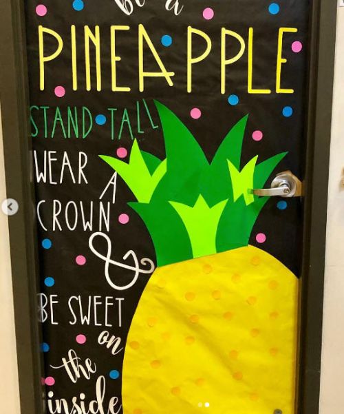 Door decorated with a large pineapple. Text reads: Be a pineapple. Stand tall, wear a crown, and be sweet on the inside.