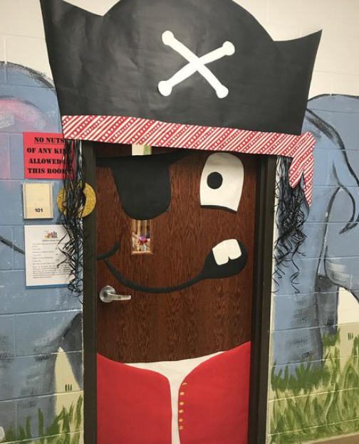 Classroom door turned into a pirate face, wearing a large paper pirate hat.
