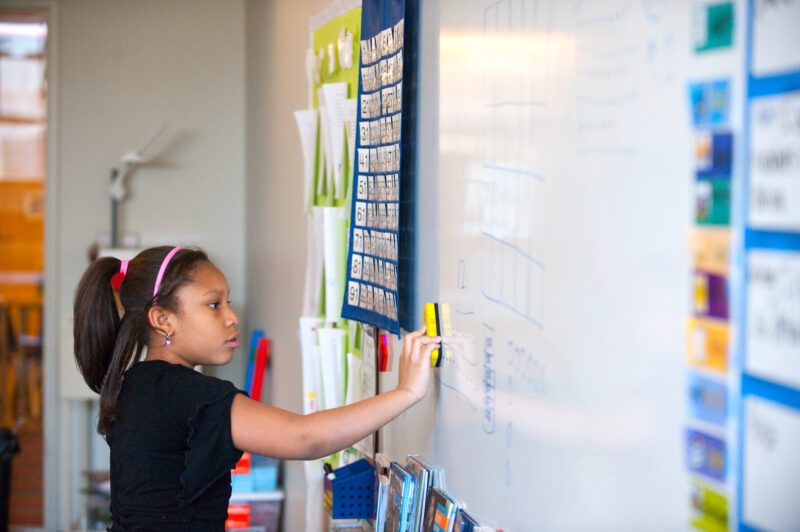 Student cleaning up whiteboard