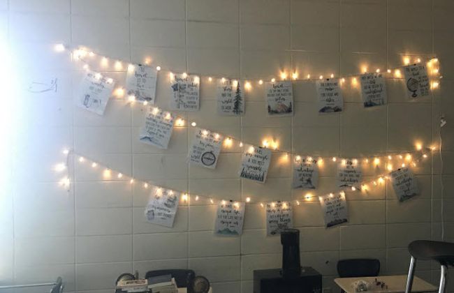 String lights on a classroom wall displaying student work
