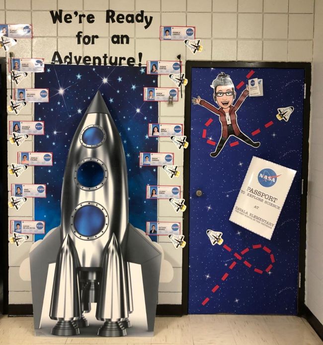 Space themed classroom door with a large cardboard rocket