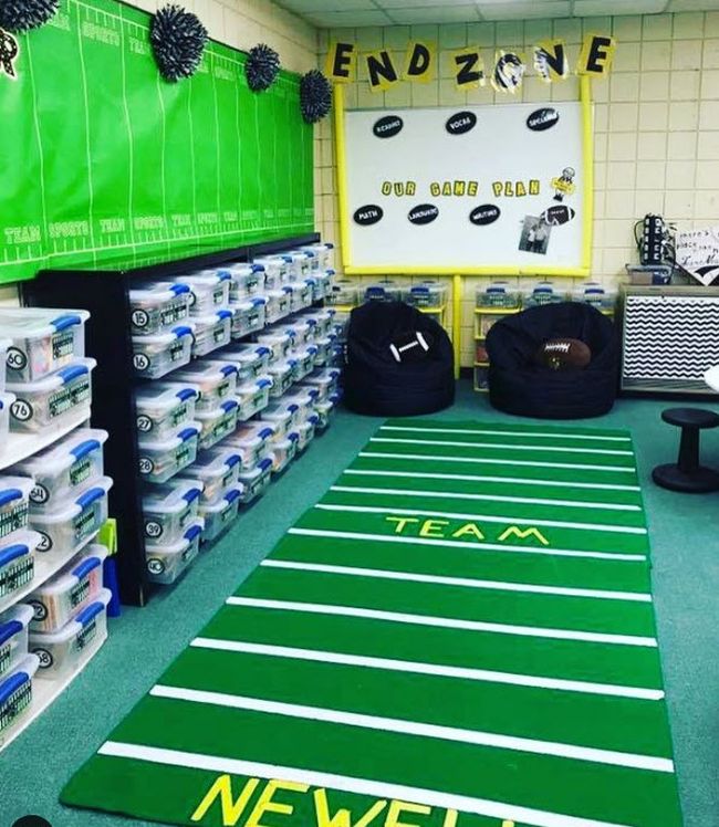 Classroom with a green rug resembling a football field, an end-zone themed bulletin board, and more sports decorations