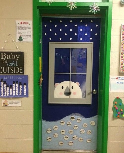 Holiday classroom doors include this one decorated with a window with a polar bear peeking through