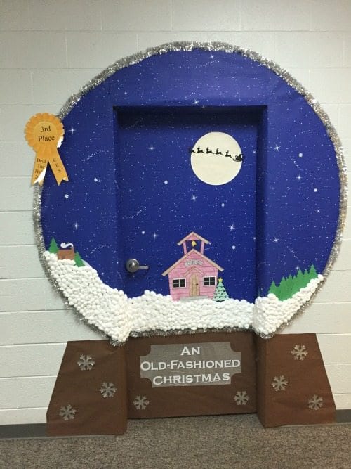 Classroom door decorated to look like a large Christmas-themed snowglobe