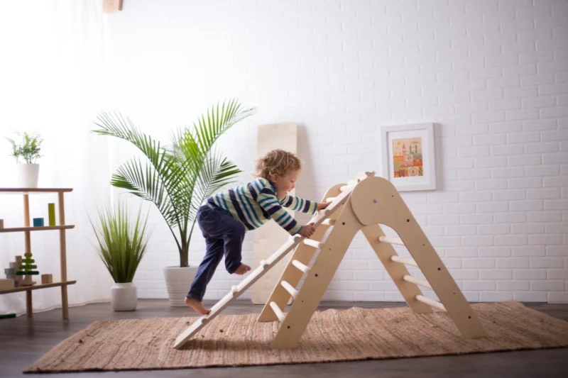Boy climbing on Montessori tower as example of Montessori toys