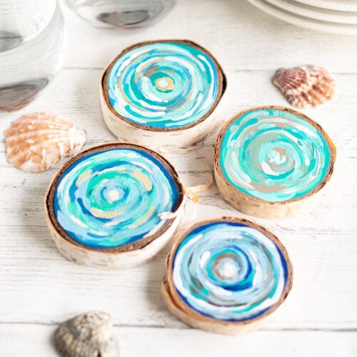 Discs of wood painted with blue paint laid out on a table as an example of summer crafts for kids