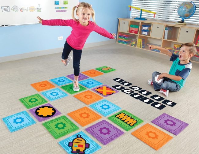 Toddler balancing their way through a maze of directional cards in the game Let's Go Code