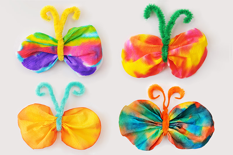 Colorful butterflies made from coffee filters, paint and pipe cleaners as an example of spring activities for preschoolers