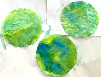 Beautiful watercolor blue and green planet Earths made from coffee filters as an example of Earth Day crafts
