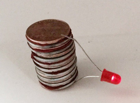 coins stacked in a tower with an l e d light