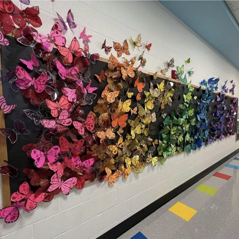 Hallway wall covered in colorful butterflies as part of a collaborative art project