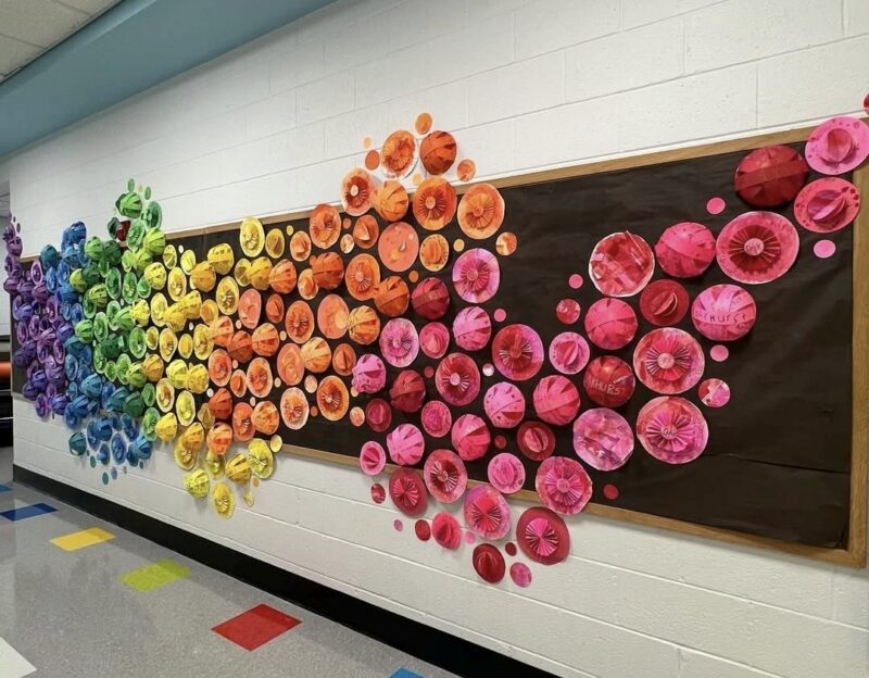 Collaborative art mural made up of a rainbow of paper dots