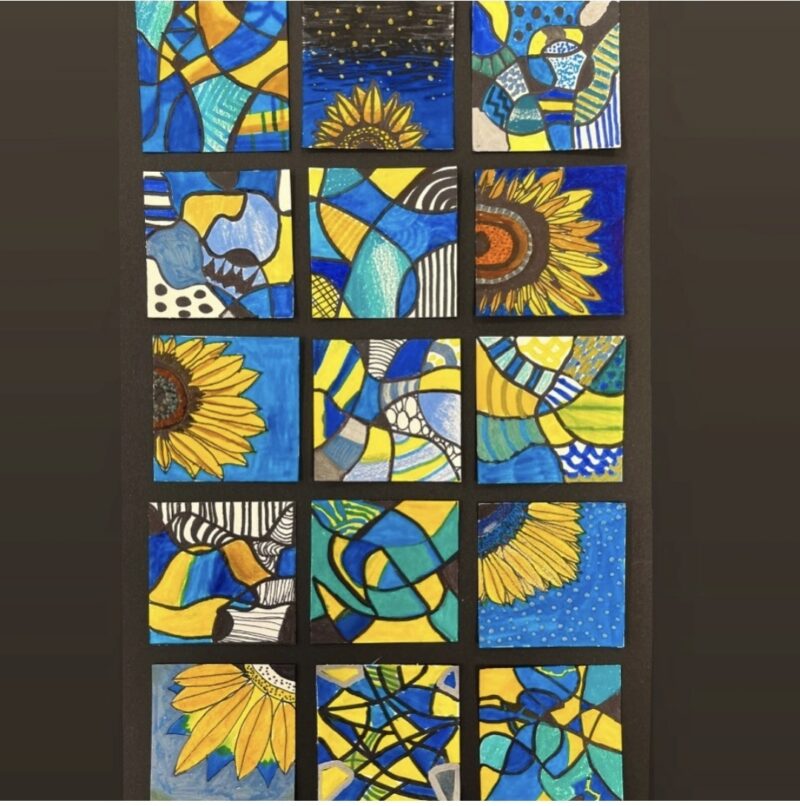 Small square canvases painted in yellows and blues with a sunflower theme, grouped together in a rectangle