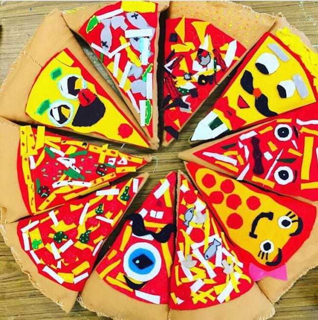 Pizza slice shaped pillows put together to form a large plush pizza