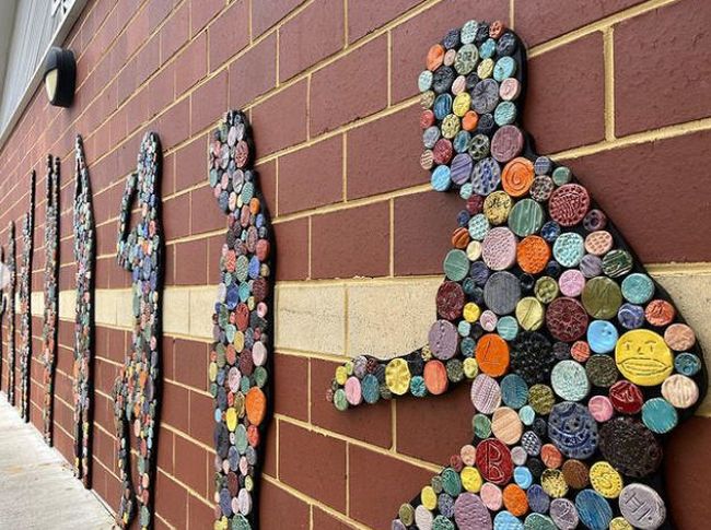Large silhouettes of kids, covered in colorful clay tiles